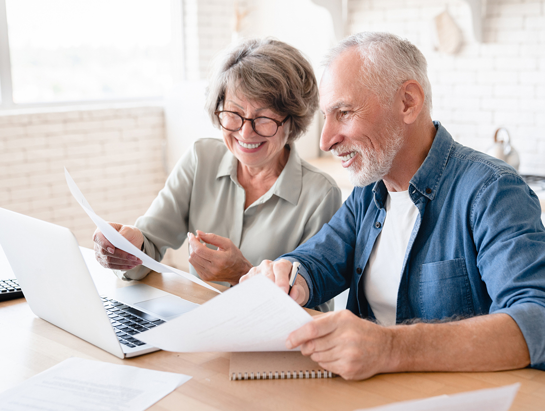 senior couple reviewing paperwork and smiling